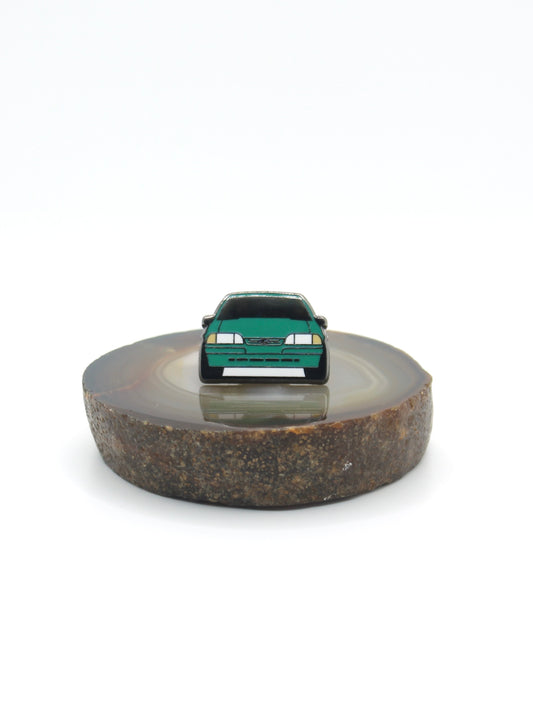 Vintage American muscle car design lapel pin. This Ford Mustang Foxbody decorative pin is offered in Ford's original paint code Bright Calypso Green. Available for a fan or as a gift for your boyfriend, girlfriend, wife, husband, etc.