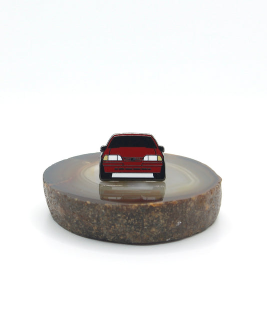 Vintage American muscle car design lapel pin. This Ford Mustang Foxbody decorative pin is offered in Ford's original paint code Scarlet Red. Available for a fan or as a gift for your boyfriend, girlfriend, wife, husband, etc.