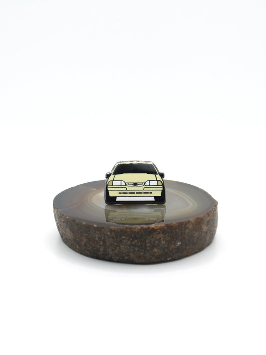 Vintage American muscle car design lapel pin. This Ford Mustang Foxbody decorative pin is offered in Ford's original paint code Tropical Yellow. Available for a fan or as a gift for your boyfriend, girlfriend, wife, husband, etc.